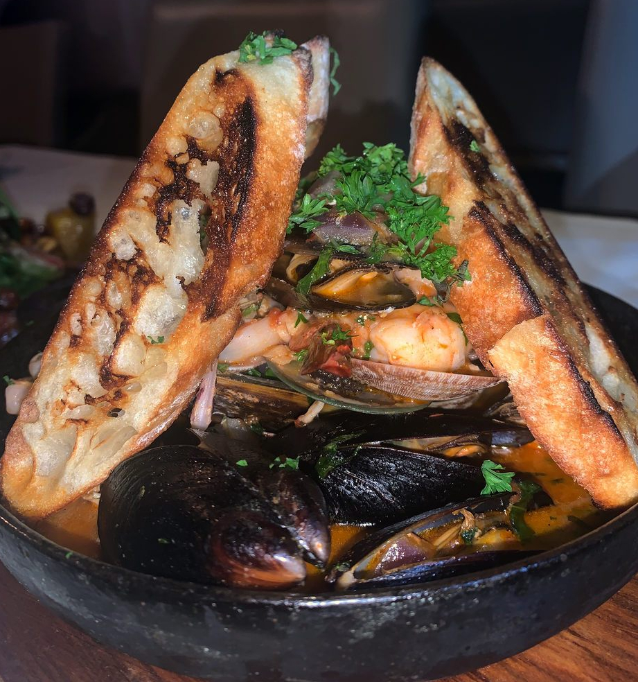 Pepata Di Cozze at Concerto, Korea Town: eppered mussels, shrimp, and clams with a white wine garlic sauce with garlic bread.